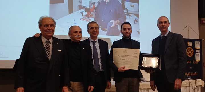 La consegna della pergamena a Marco Cocco, nella foto con i membri della commissione del Rotary per il Premio Angelo Aru. A sinistra il professor Giovanni Barrocu, a destra il presidente del club Rotary Cagliari Roberto Nati