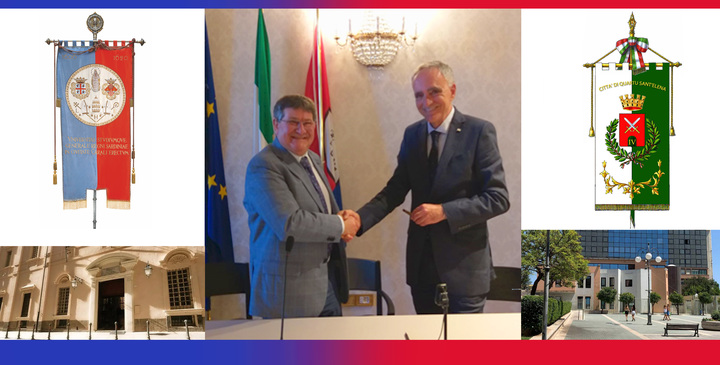 La stretta di mano del magnifico rettore dell'Universit&agrave; di Cagliari, Francesco Mola (a sinistra), con il sindaco del Comune di Quartu Sant'Elena, Graziano Milia. Nell'immagine anche gli stendardi e le rispettive sedi delle due istituzioni