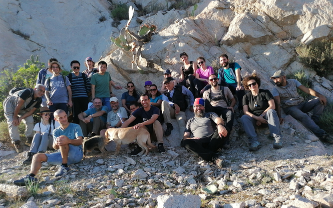 Foto di gruppo dei partecipanti nella cava di granito di San Priamo. I due speaker, Janousek e Moyen, in seconda fila dietro a due amici a quattrozampe con l&rsquo;hobby della geologia