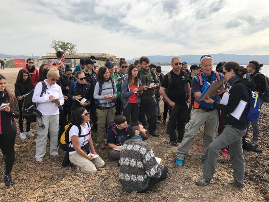 Un momento della lezione in spiaggia: Sandro Demuro mostra dei dati con il supporto di Carla Buosi