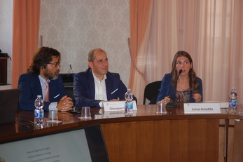 Luisa Anedda espone il contenuto della tesi nel corso della cerimonia in Rettorato. A sinistra Giovanni Marini, avvocato e funzionario dell'Ateneo, e Giovanni Caocci, docente alla Facolt&agrave; di Medicina e chirurgia, componente della commissione esaminatrice