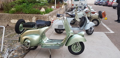 In primo piano uno splendido esemplare di Vespa a faro basso del 1950, con comando a bacchetta del cambio di velocit&agrave;