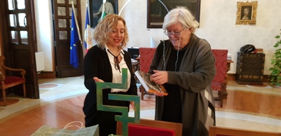 Le professoresse Daniela Zizi (a sinistra) e Maria Del Zompo. Il Rettore sfoglia l'edizione del libro "El&iacute;as Vali&ntilde;a, il paladino del Cammino", in primo piano la scultura "Harmonia"