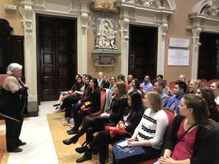 Tra il gonfalone e il logo dell'ateneo, la bandiera dei Quattro mori, della Repubblica e dell'Unione Europea, spiccano i volti sorpresi degli universitari stars and stripes